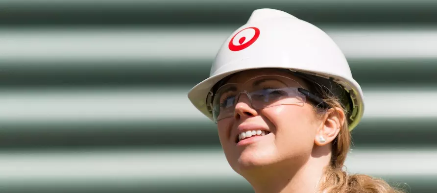 Eine Veolia Mitarbeiterin mit Schutzhelm lächelt