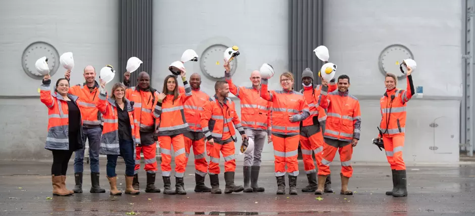 Viele Veolia Mirarbeiter halten den Sicherheitshelm nach oben