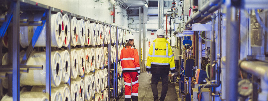 Zwei Veolia Mitarbeiter gehen in einer Halle